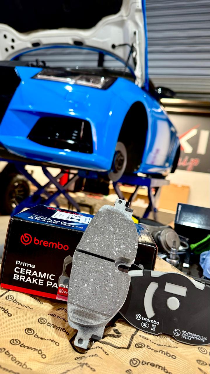 Pastilhas de freio Brembo na oficina Maxi Chip, com Audi ao fundo